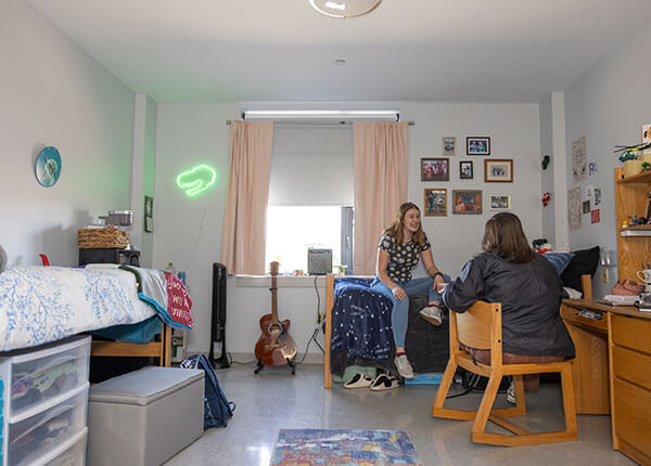 students hanging out in their room in Hawk Hall