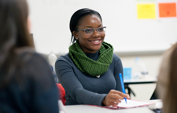 Image is of a woman sitting in a classroom