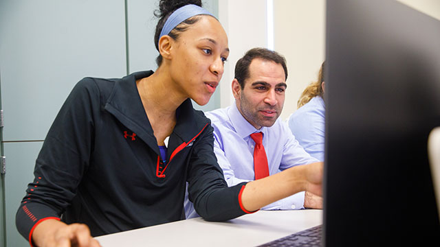 Student and professor looking at a computer screen.