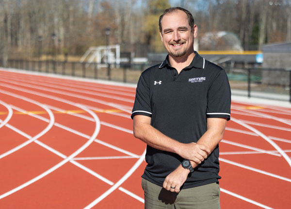 The head coach for University of Hartford's cross country and track and field teams stands on the newly built track.