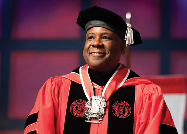 President Lawrence P. Ward posing in a red UHart robe at his inauguration ceremony.