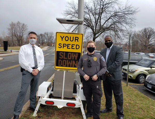 Photo of pubic safety officers and a speed monitoring sign